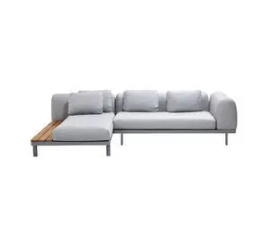 Modulsofa i lys grå med L-form, ryghynder og træudvidelse på den ene side. Minimalistisk design.